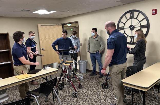 Team of WSU senior mechanical engineers working with a prototype of a new adjustable walker.