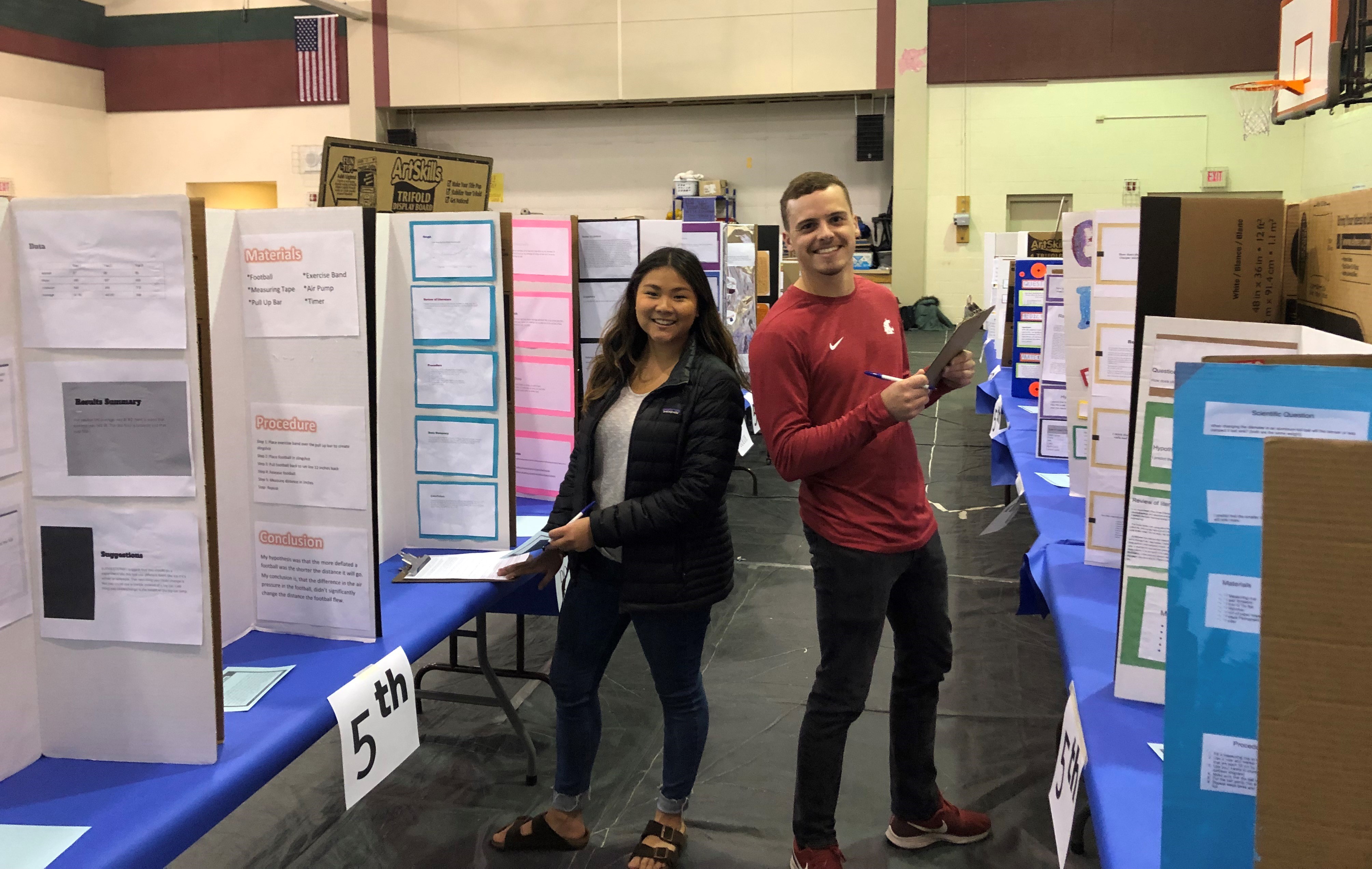 Teaching Elementary Science (T&L 371) students reviewing Franklin Elementary students' science fair projects.