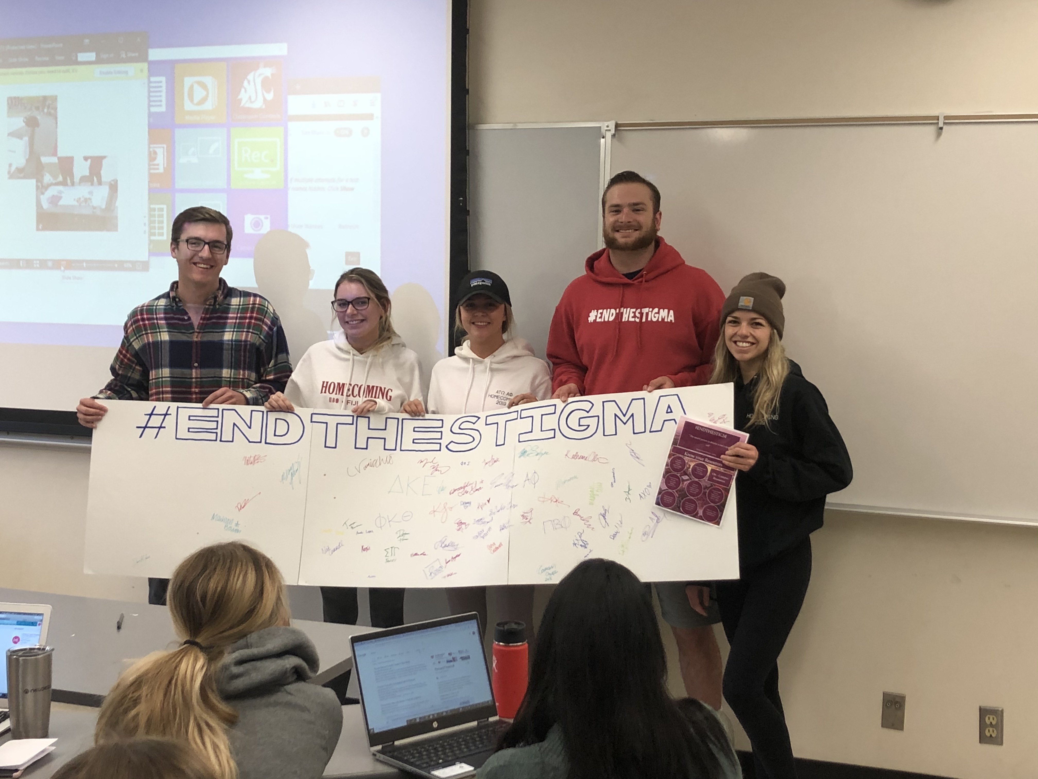 students holding up a sign that says #EndTheStigma